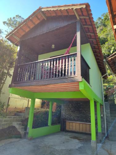 a house with a deck on the side of it at Pousada Solar das Flores Maringá RJ Visconde de Mauá in Visconde De Maua
