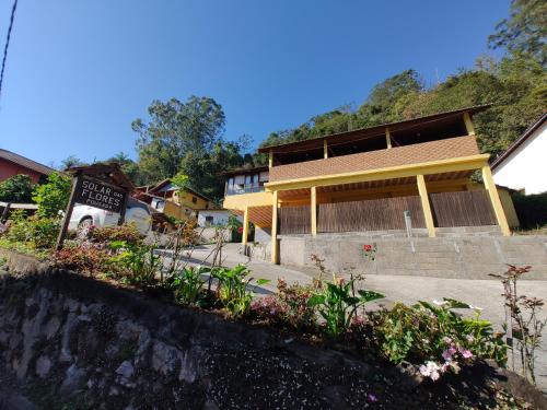 a building with a bunch of flowers in front of it at Pousada Solar das Flores Maringá RJ Visconde de Mauá in Visconde De Maua