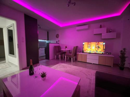 un salon avec éclairage violet et télévision dans l'établissement Apartman PANDA deluxe Sarajevo, à Sarajevo