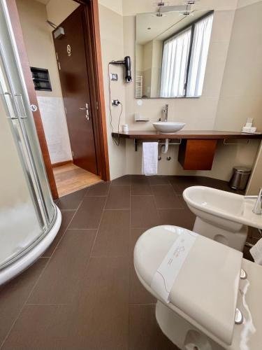 a bathroom with a toilet and a sink and a mirror at Hotel Lovere Resort & Spa in Lovere