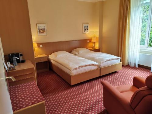 a hotel room with a bed and a chair at Elite in Lausanne