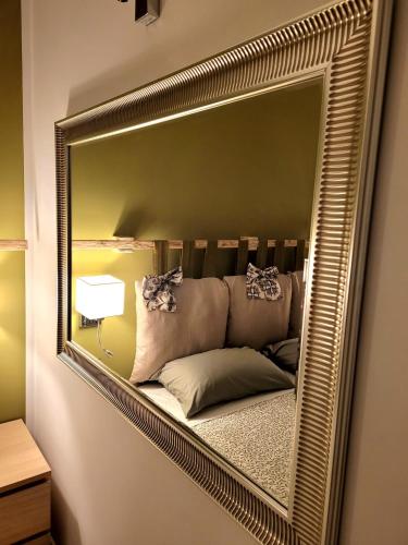 a mirror hanging on a wall with a couch in it at Pompei Suite in Pompei