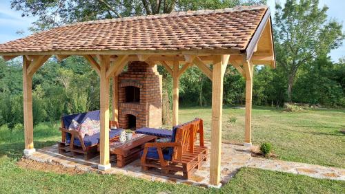 a wooden gazebo with two chairs and a table at Kuća za odmor Filipović in Gornji Milanovac