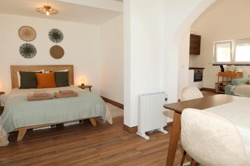 a bedroom with a bed and a dining room at Casa com pátio-São Lourenço-Ericeira in Casais de São Lourenço