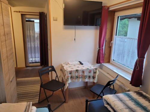 a small room with a table and chairs and a window at Pension Haus Rohrmoser in Annaberg im Lammertal