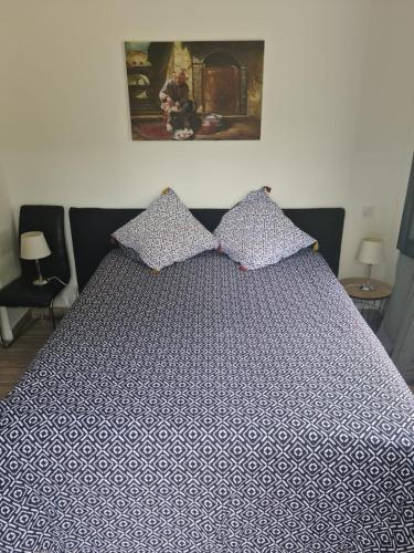 1 cama grande con edredón azul y blanco en Cherad, en Arveyres