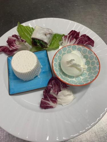 a white plate with a plate of food on a table at Il Poggio del Mare in San Mauro Cilento
