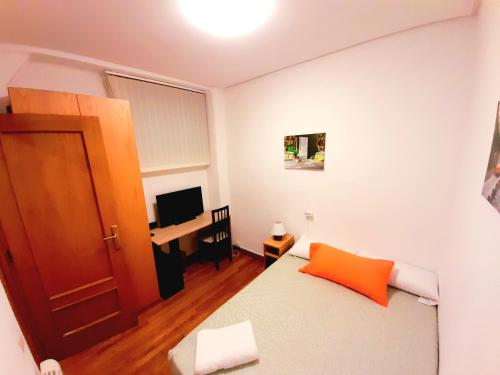 Kleines Zimmer mit einem Bett und einem TV in der Unterkunft Habitación céntrica en Pamplona in Pamplona