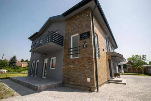 a brick building with a balcony on the side of it at Apartman Paratetis 1 in Palić