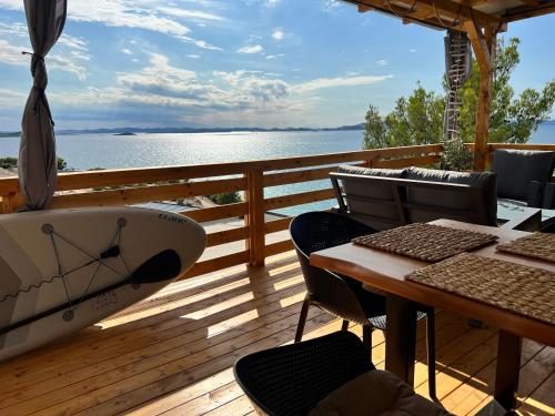 ドラゲにあるd-view Premium Mobile Home - panoramic seaview - 150 m from beach, free parkingのテーブルと椅子が置かれたデッキに停泊しているボート