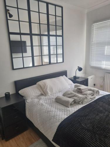 een slaapkamer met een bed met handdoeken erop bij Manhattan Studio flat northbridge services in Londen