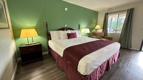 a hotel room with a large bed and a window at Colonial Inn Franklin in Franklin