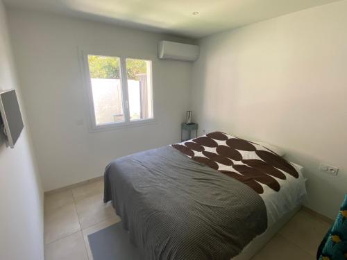 une chambre avec un lit et une fenêtre dans l'établissement JOLIE MAISON A 700M DE LA MER, au Grau-dʼAgde