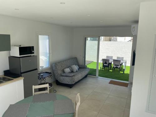 un salon avec un canapé et une table dans l'établissement JOLIE MAISON A 700M DE LA MER, au Grau-dʼAgde