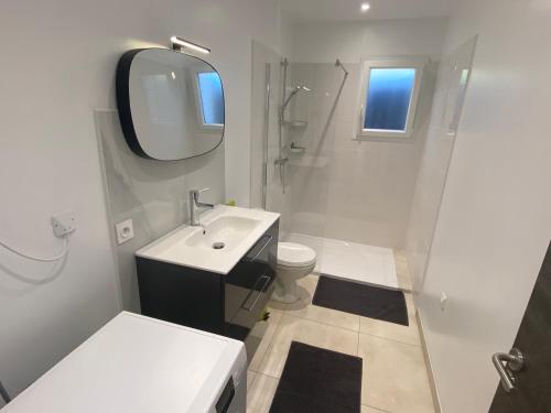 une salle de bain blanche avec un lavabo et un miroir dans l'établissement JOLIE MAISON A 700M DE LA MER, au Grau-dʼAgde