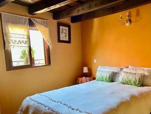 a bedroom with a large bed and a window at Casa Artista in Pedro Bernardo