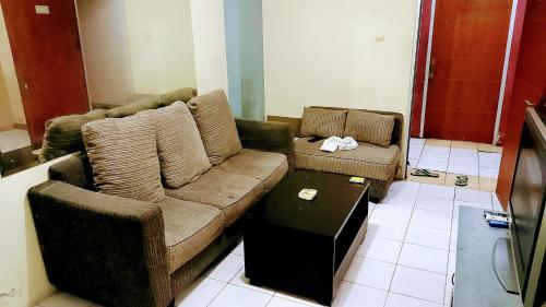 un soggiorno con divano e tavolino da caffè di Apartemen Cibubur village by ipol a Cisalak