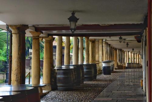 an empty hallway with columns and trash cans at Puerta la Villa in Avilés