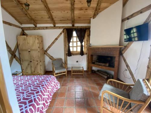ein Schlafzimmer mit einem Bett und einem Kamin in einem Zimmer in der Unterkunft The Hideout- A Cabin in Nature; 25 min from Cuenca in Cuenca