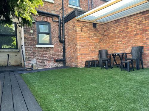 a patio with chairs and a table in a yard at Juz Apartments Manchester airport in Altrincham