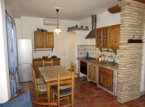 uma cozinha com uma mesa e uma cozinha com um frigorífico em Casa lago di Bolsena em Bolsena