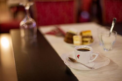 a cup of coffee and a plate of food on a table at Hotel Regal in Braşov
