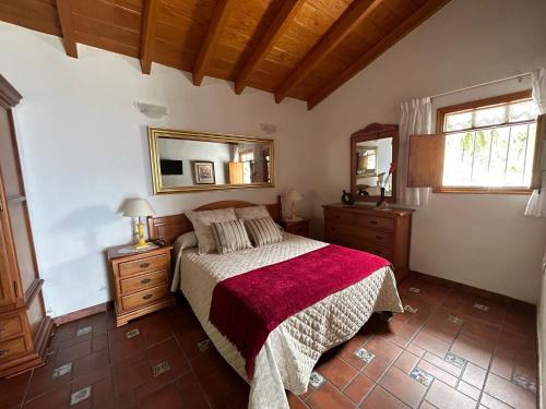 een slaapkamer met een bed met een rode deken bij Casa Rural Los Barros in Genovés