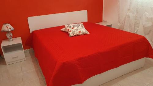 a red bedroom with a red bed with a pillow at La Dimora del Frappato di Tenute Senia in Chiaramonte Gulfi