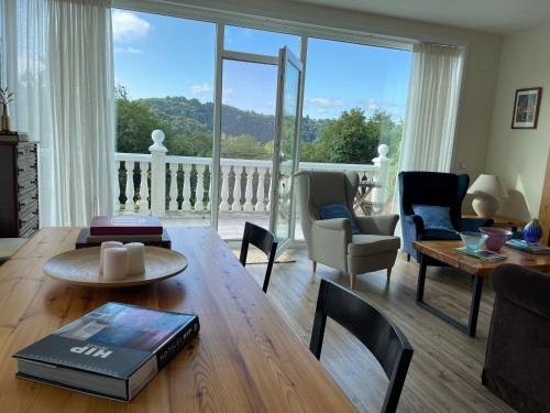 a living room with a table and a large window at Casa Acougo, Sarria in Sarria