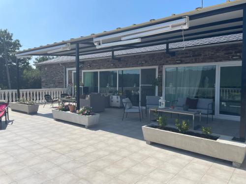 a patio with chairs and tables and a building at Casa Acougo, Sarria in Sarria
