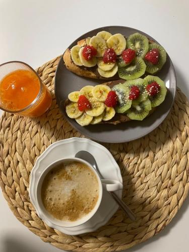 a table with a plate of fruit and a cup of coffee at Casa Acougo, Sarria in Sarria