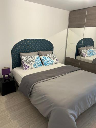 - une chambre avec un lit doté d'une tête de lit et d'oreillers bleus dans l'établissement Gite Paon, à Kintzheim