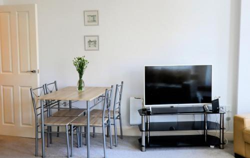 イプスウィッチにあるLuxury 2-Bed Flat Central Ipswich Parkingのテーブルとテレビのあるダイニングルーム