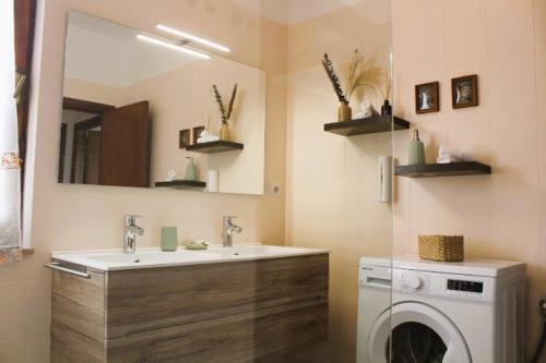 a bathroom with a sink and a washing machine at Casa Luisa in Pitigliano