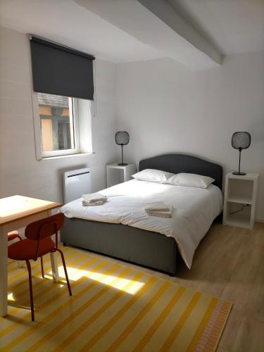 une chambre avec un lit, un bureau et une fenêtre dans l'établissement Le 1 St Yves Studios, à Tréguier