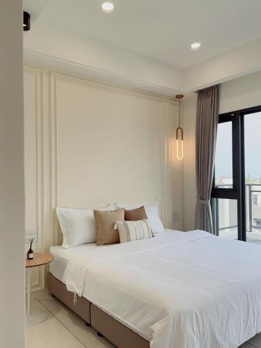 Schlafzimmer mit einem großen weißen Bett und einem großen Fenster in der Unterkunft Muzhu B&B in Yilan