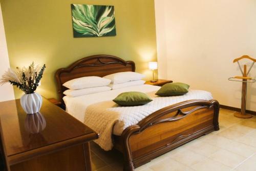 um quarto com uma cama com almofadas verdes e uma mesa em Casa Luisa em Pitigliano