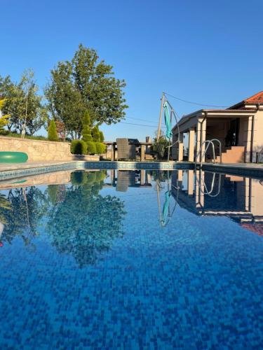 una piscina de agua azul y un parque infantil en Club12 pool house, en Čačak