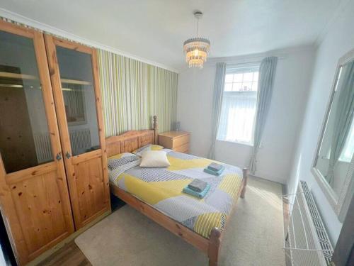 a bedroom with a bed and a chandelier at 3-bedroom house - Thornton Heath in Thornton Heath