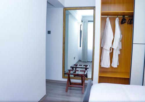 a bedroom with a mirror and a bed and a chair at Rose Manor - Cozy Luxurious 2 Bedroom Apartment in Kilimani Nairobi in Nairobi