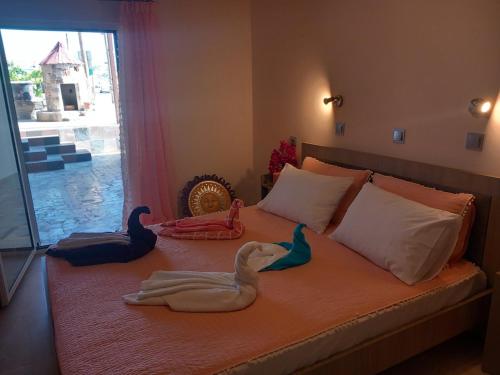 Una cama con dos cisnes encima. en Anemomylos House en Kámpos