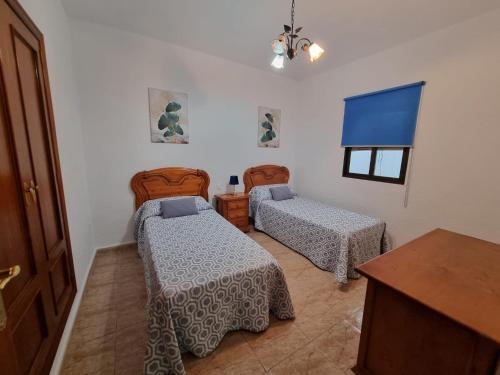 1 dormitorio con 2 camas, mesa y ventana en AT SAN PEDRO 2, en Olivenza
