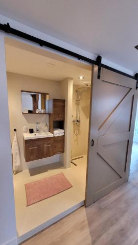 a bathroom with a sliding door and a sink at Dream Boutique Edam Coffee & Comfort in Edam