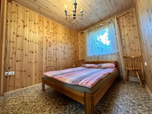 una camera con un letto su una parete in legno di Apartamentai su pirtimi a Klaipėda