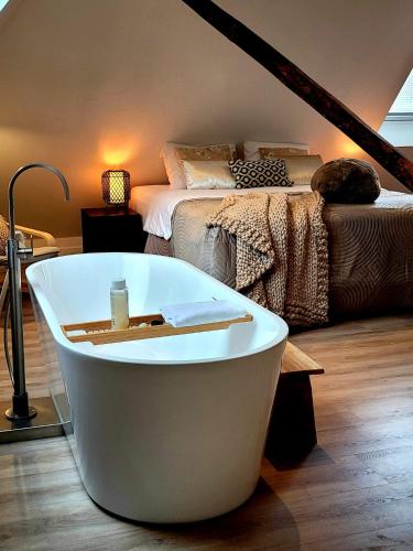 a bath tub in a room with a bed at Dream Boutique Edam Coffee & Comfort in Edam