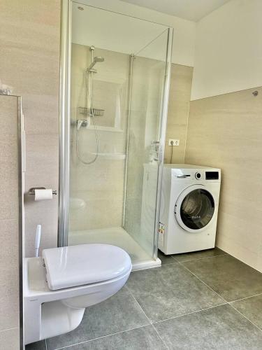 a bathroom with a washing machine and a washer at Großes City-Ferienhaus mit Terrasse, Grill und Parkplatz F19 in Oldenburg