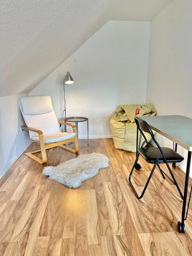a living room with a desk and a chair and a table at Großes City-Ferienhaus mit Terrasse, Grill und Parkplatz F19 in Oldenburg