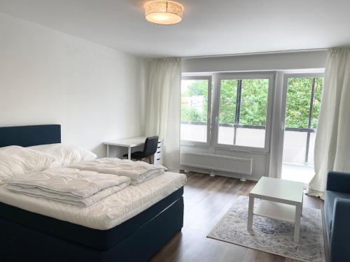 a bedroom with a bed and a desk and windows at Zentrale Wohnung mit 3 Schlafzimmer für bis zu 9 Personen in Hamburg