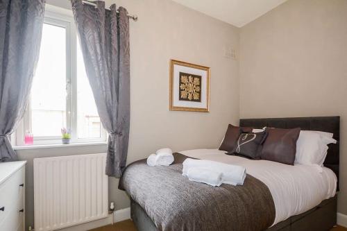 a bedroom with a bed with two towels on it at New - Prospect lodge , City Centre Terraced House in York