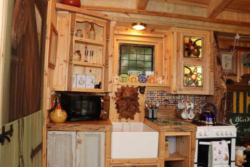 a kitchen with wooden cabinets and a white refrigerator at Cushieston’s Shepherd’s Hut in Meikle Wartle